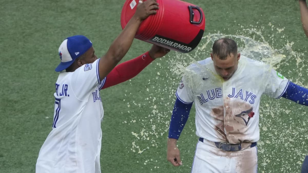 Toronto Blue Jays designated hitter George Springer (4) gets doused with a second bucket of a sport drink by first baseman Vladimir Guerrero Jr. (27) following a win over the Tampa Bay Rays during the ninth inning at Rogers Centre.