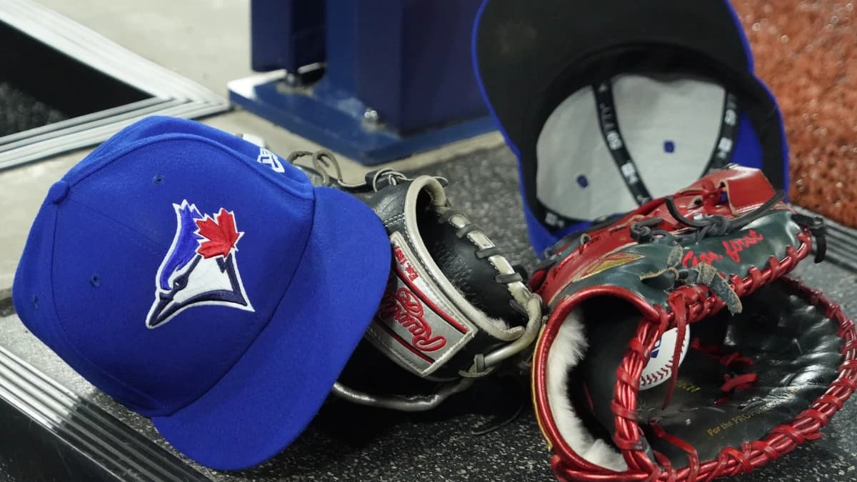 A pair of Toronto Blue Jays hats and gloves in the dugout during the first inning against the Los Angeles Dodgers at Rogers Centre