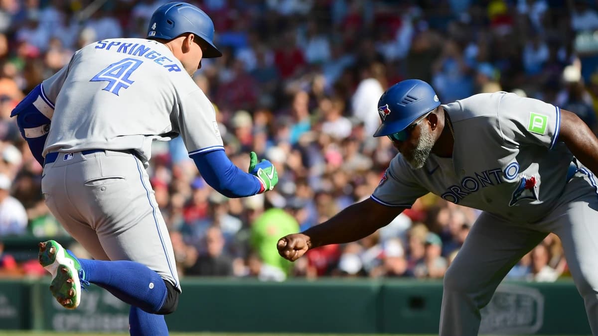 Toronto Blue Jays designated hitter George Springer (4) reacts with third base coach Carlos Febles (51) after hitting a three run home run during the third inning against the Boston Red Sox at Fenway Park.