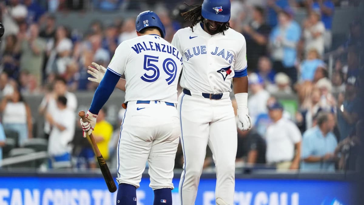 Toronto Blue Jays third baseman Charles McAdoo (26) hits a home run and celebrates with catcher Brandon Valenzuela (59) during the fifth inning against the Boston Red Sox at Rogers Centre.