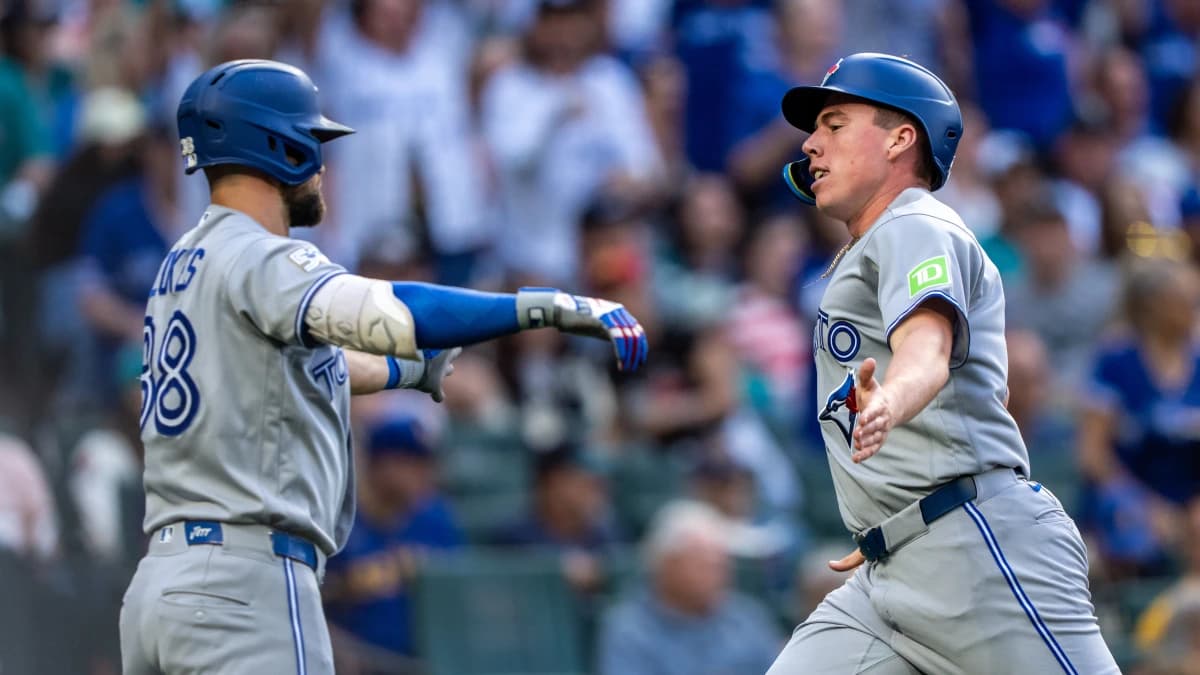 Toronto Blue Jays designated hitter Sean Keys (20), right, is congratulated by right fielder Nathan Lukes (38) after scoring a run during the third inning against the Seattle Mariners at T-Mobile Park.