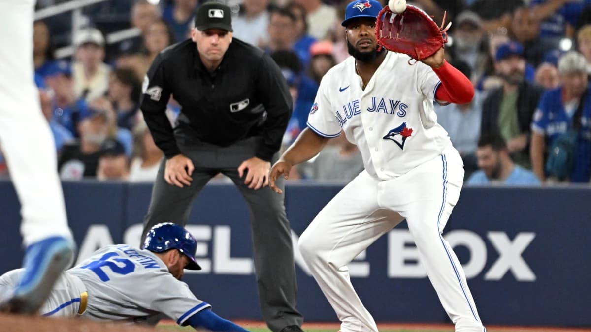 Toronto Blue Jays first baseman Vladimir Guerrero Jr. (27) catches a pickoff throw as Kansas City Royals third baseman Nick Loftin (12) dives back to first base in the sixth inning at Rogers Centre.