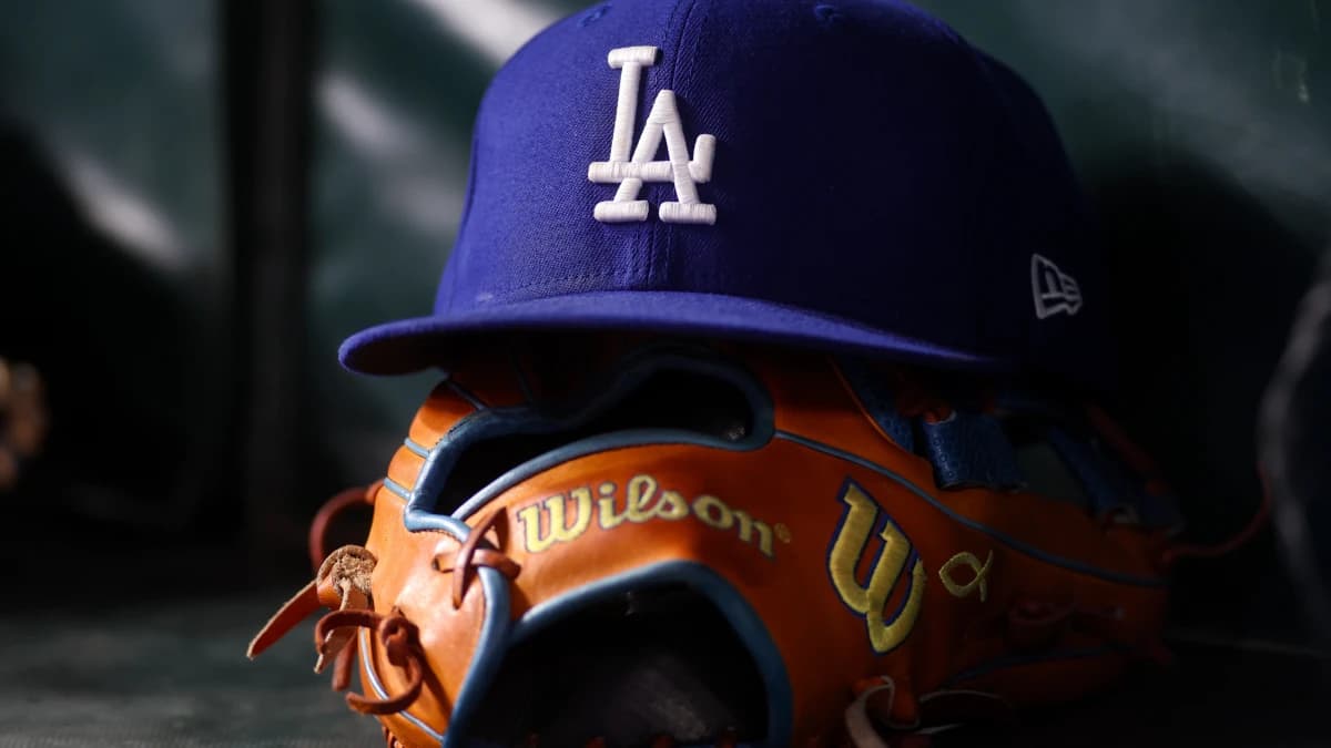 A detailed view of a Los Angeles Dodgers hat and glove on the bench against the Atlanta Braves in the eighth inning at Truist Park.