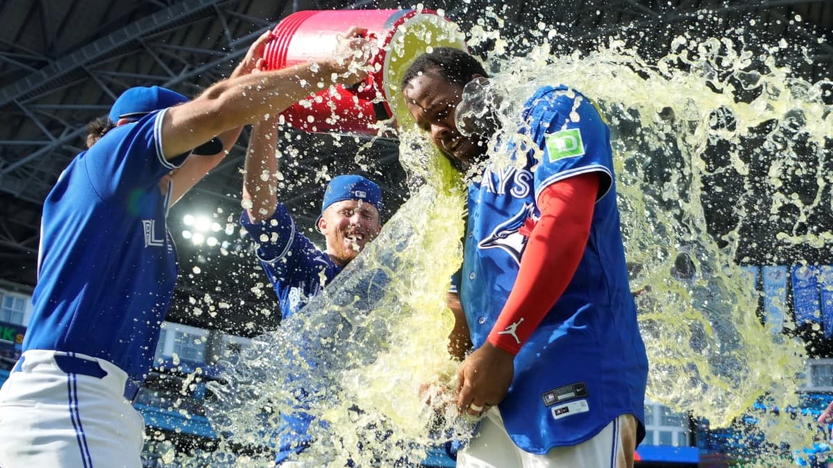 Toronto Blue Jays infielder Josh Smith (left) and center fielder Myles Straw (3) douse first baseman Vladimir Guerrero Jr. (27) with a sport drink after a win over the Baltimore Orioles at Rogers Centre.
