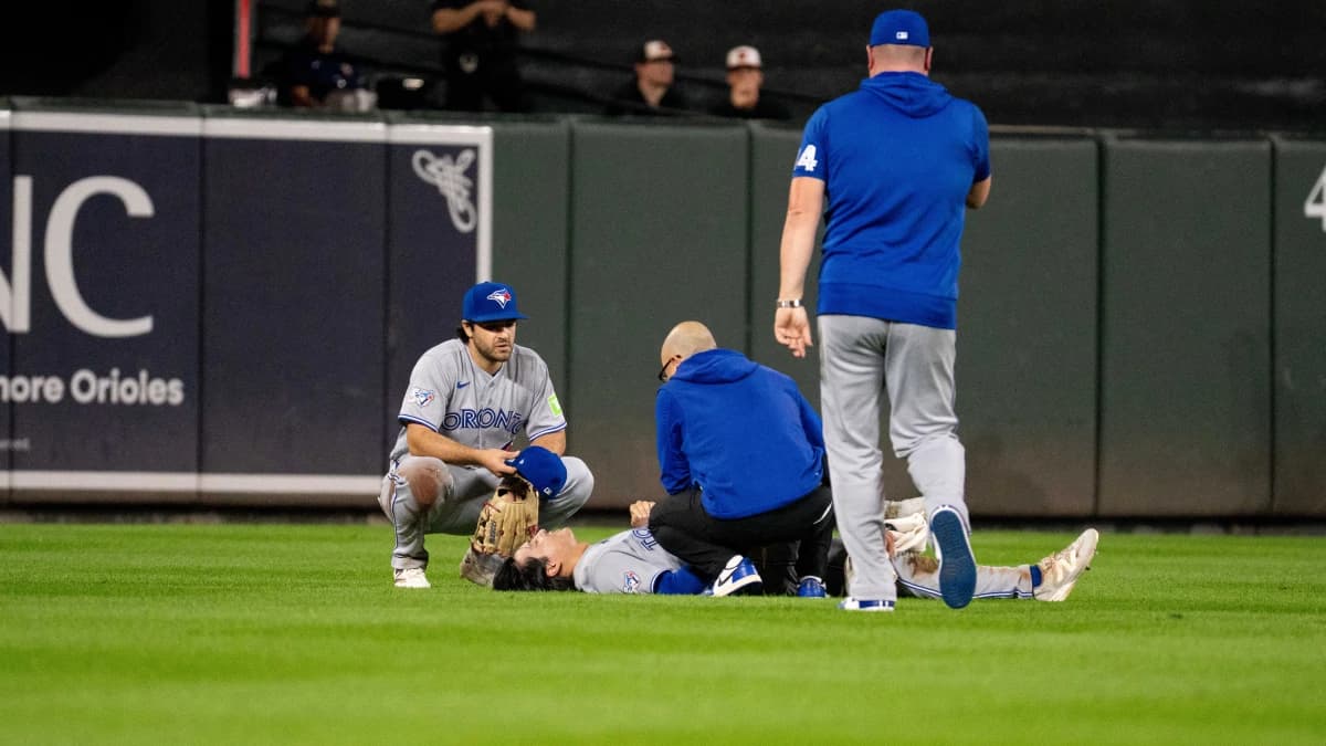Toronto Blue Jays outfielder Brett Bateman (21) is tended to by training staff after suffering an apparent injury during the second inning at Oriole Park at Camden Yards