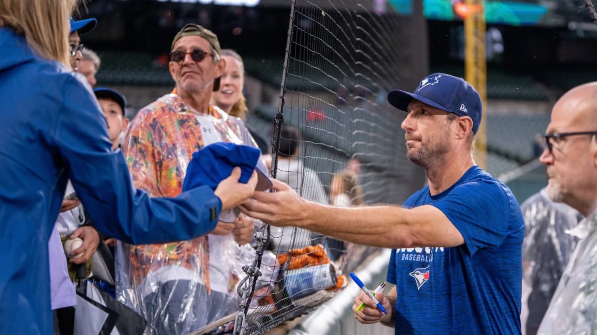 Toronto Blue Jays pitcher Max Scherzer (31) signs autographs for fans pregame at Oriole Park at Camden Yards.