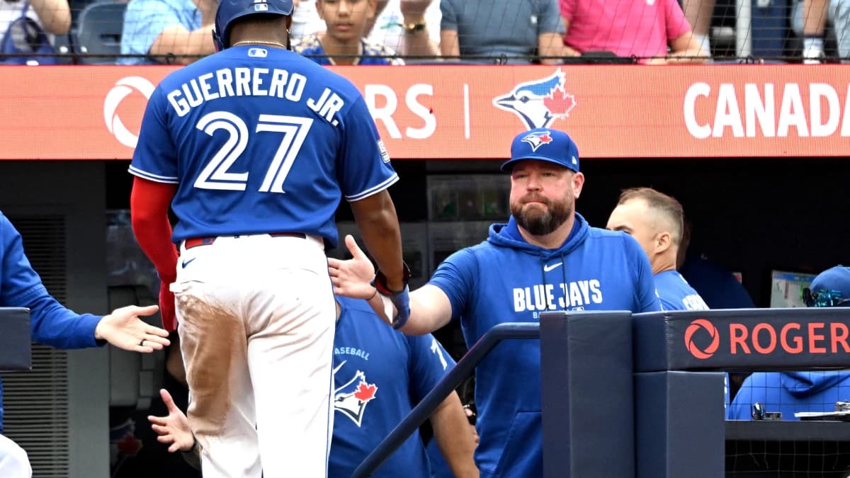 Toronto Blue Jays manager John Schneider (14) greets first baseman Vladimir Guerrero Jr. (27) after he scored a run against the Baltimore Orioles in the seventh inning at Rogers Centre.