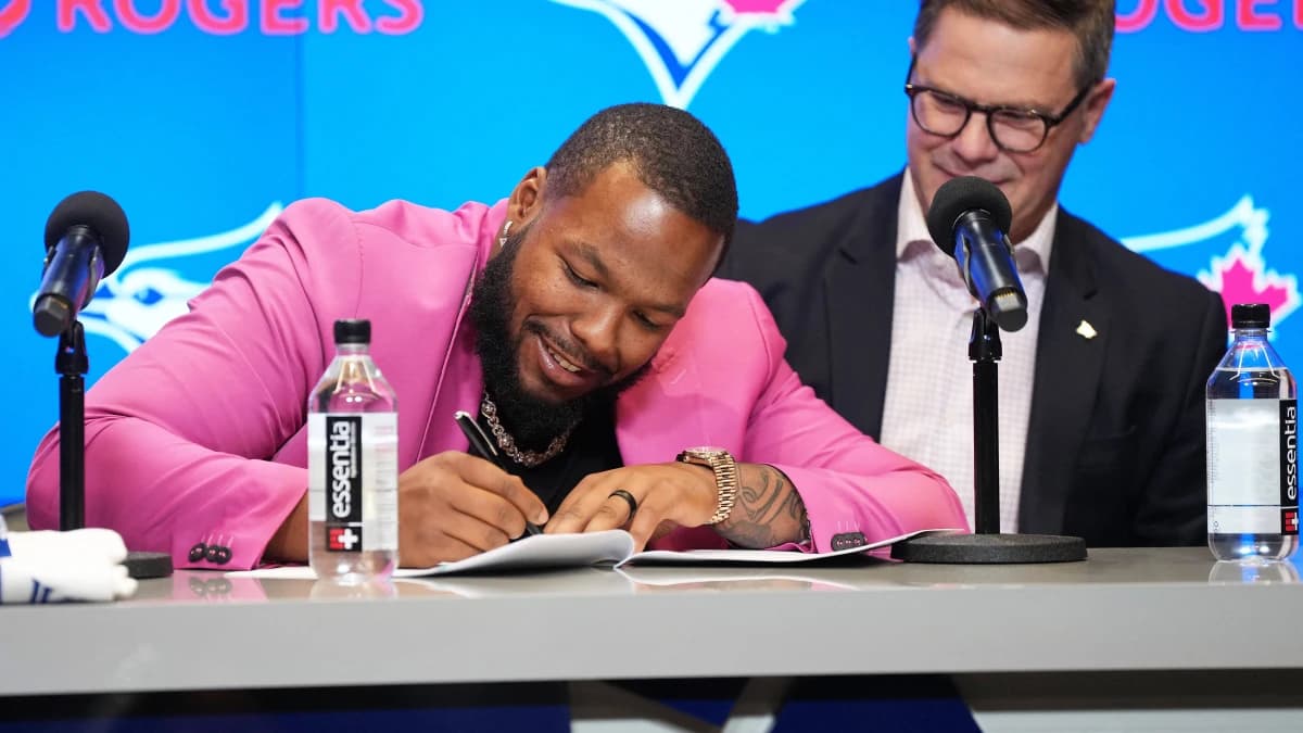Toronto Blue Jays first baseman Vladimir Guerrero Jr. signs the contract with general manager Ross Atkins during the Toronto Blue Jays press conference at Rogers Centre.