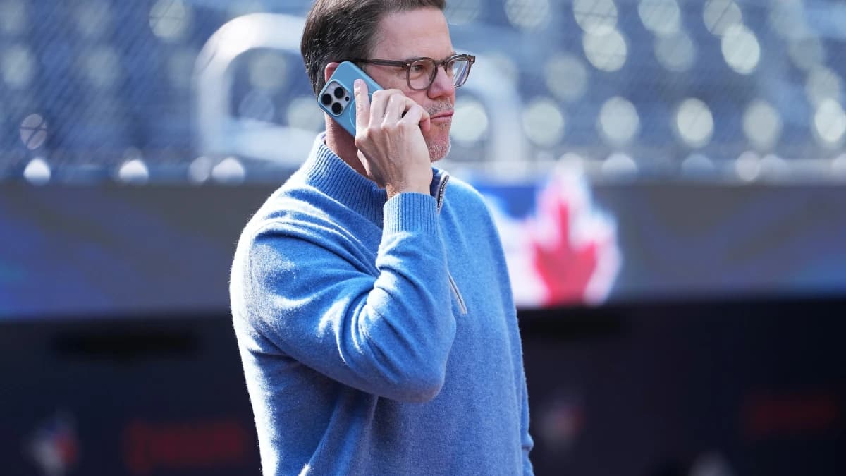 Toronto Blue Jays general manager Ross Atkins talks on the phone during batting practice before a game against the Baltimore Orioles at Rogers Centre