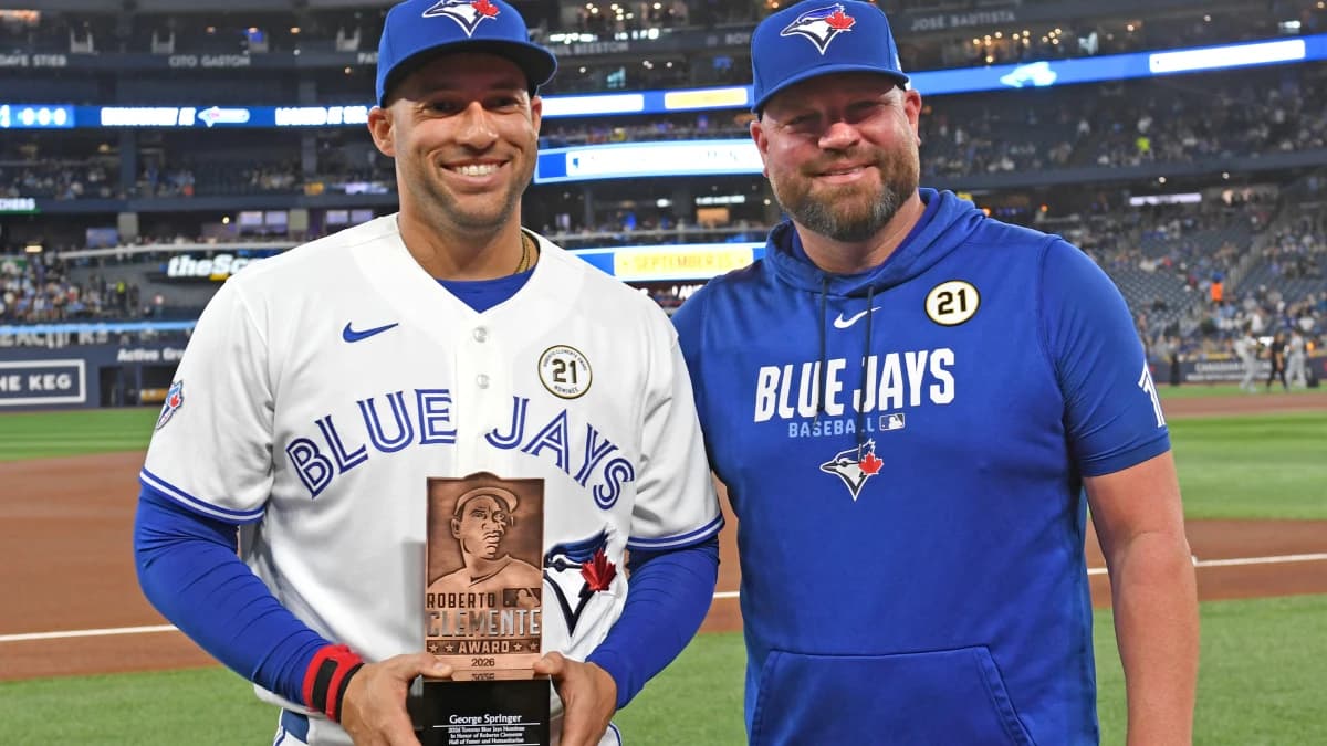 Toronto Blue Jays designated hitter George Springer (4) receives the team Roberto Clemente award from manager John Schneider (14) before play against the Detroit Tigers at Rogers Centre.