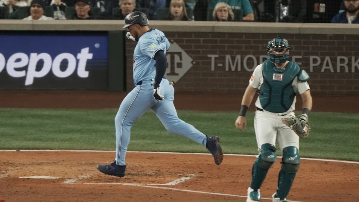 Toronto Blue Jays right fielder Anthony Santander (25) scores in the fifth inning behind Seattle Mariners catcher Cal Raleigh (29) during game three of the ALCS round for the 2025 MLB playoffs at T-Mobile Park.