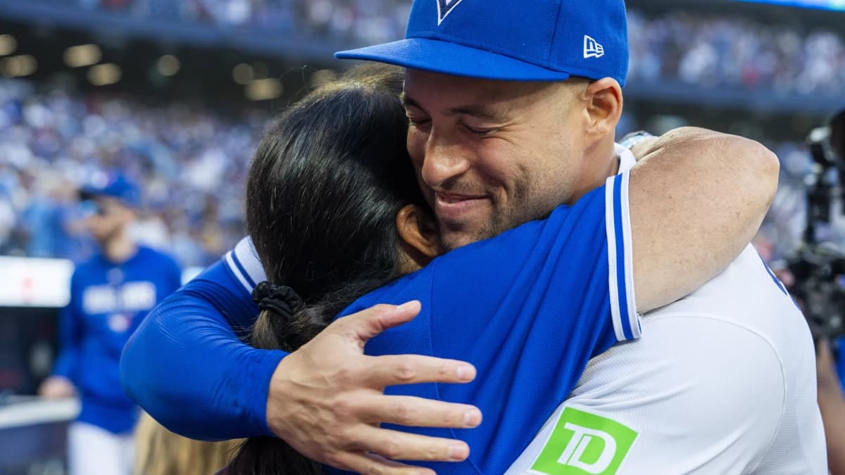 Toronto Blue Jays designated hitter George Springer (4) hugs his mother after defeating the Cincinnati Reds and calling it a career at Rogers Centre