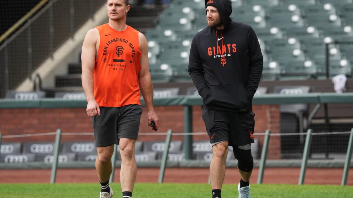 San Francisco Giants third baseman Matt Chapman (left) and second baseman Casey Schmitt (right) walk on the field before the game against the Colorado Rockies at Oracle Park.