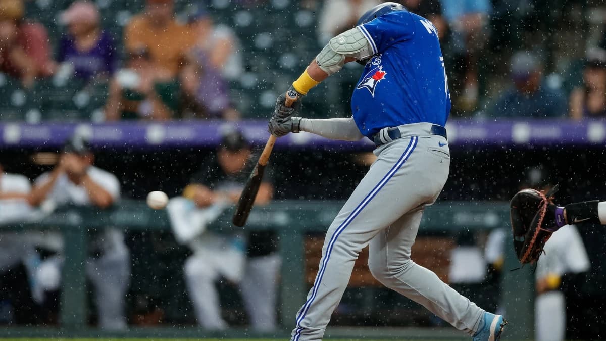Toronto Blue Jays left fielder Whit Merrifield (15) hits an RBI single in the ninth inning against the Colorado Rockies at Coors Field.
