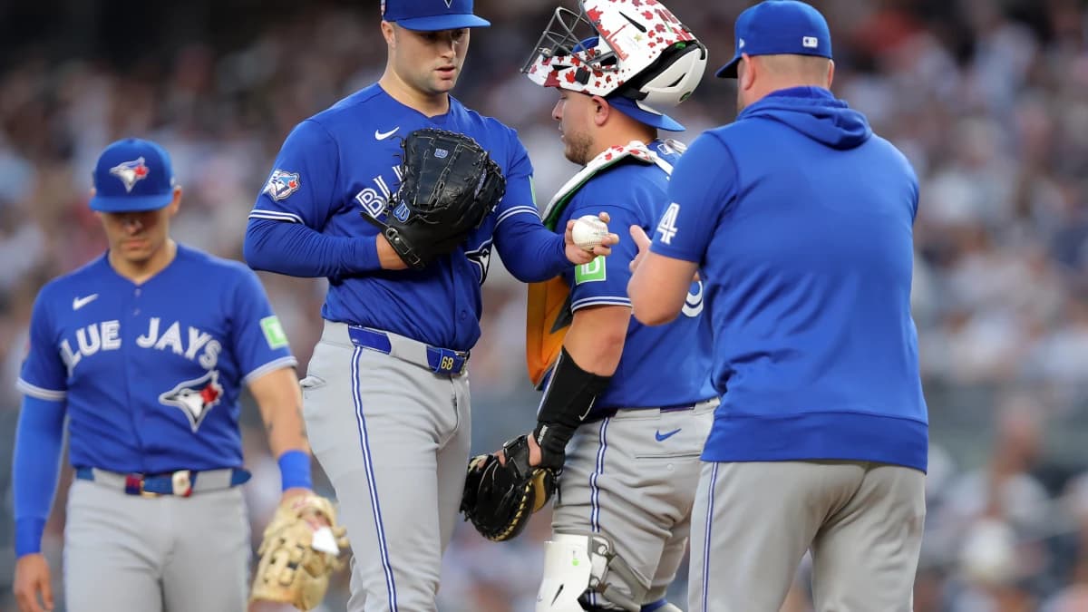 Toronto Blue Jays starting pitcher Mason Fluharty (68) hands the ball to Toronto Blue Jays manager John Schneider (14) during a pitching change during the first inning against the New York Yankees at Yankee Stadium