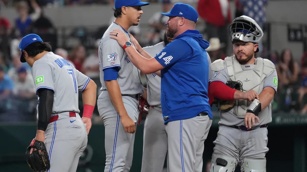 Toronto Blue Jays manager John Schneider (14) places his hands on the shoulders of pitcher Jose Rodriguez (64) prior to pitching in his major league debut against the Texas Rangers during the sixth inning at Globe Life Field