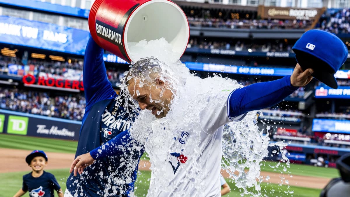 Toronto Blue Jays designated hitter George Springer (4) gets water dumped on him by first baseman Vladimir Guerrero Jr. (27) and his children after defeating the Cincinnati Reds at Rogers Centre.