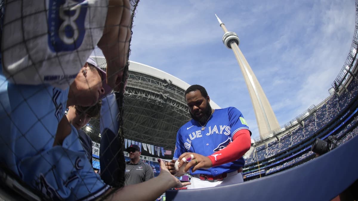 Toronto Blue Jays designated hitter Vladimir Guerrero Jr. (27) gives a fan an autograph before a game against the Cincinnati Reds at Rogers Centre.