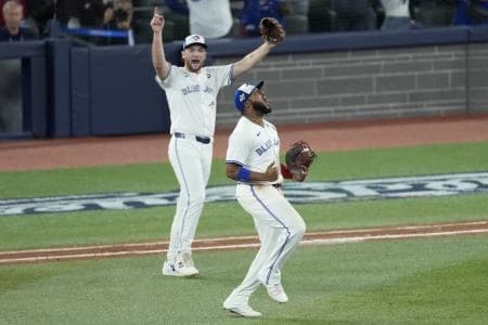 Toronto Blue Jays first baseman Vladimir Guerrero Jr. (27) and pitcher Trey Yesavage (39) react after a double play against the Los Angeles Dodgers in the seventh inning during game seven of the 2025 MLB World Series at Rogers Centre.