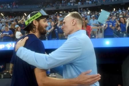 Toronto Blue Jays pitcher Kevin Gausman (34) is greeted by club president Mark Shapiro as they celebrate a win over the Tampa Bay Rays that clinched first place in the American League East Division at Rogers Centre.