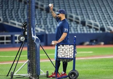 Toronto Blue Jays hitting coach David Popkins (79) uses the pitching machine to pitch balls during early batting practice before a game against the Baltimore Orioles at Rogers Centre.