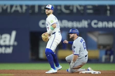 Los Angeles Dodgers third baseman Max Muncy (13) is out against Toronto Blue Jays designated hitter Bo Bichette (11) in the sixth inning during game seven of the 2025 MLB World Series at Rogers Centre.