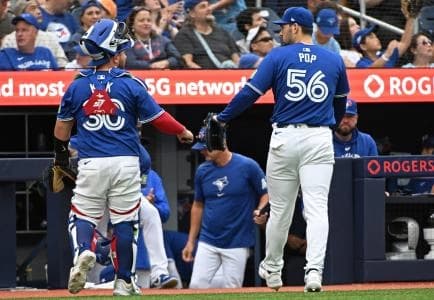 Toronto Blue Jays catcher Alejandro Kirk (30) and Toronto Blue Jays pitcher Zach Pop (56) celebrate the last out of the ninth inning against the Oakland Athletics at Rogers Centre.