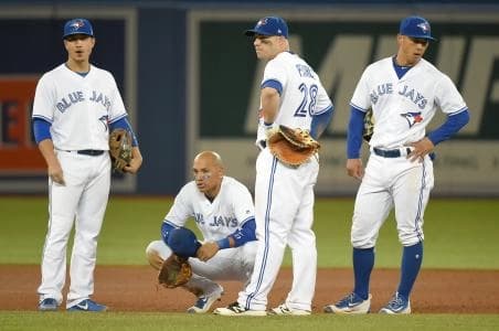 Toronto Blue Jays players gather and watch a pitching change against Boston Red Sox in the eighth inning at Rogers Centre. From left are third baseman Darwin Barney (18), shortstop Ryan Goins (17) , left fielder Steve Pearce (28) and second baseman Rob Refsnyder (39)