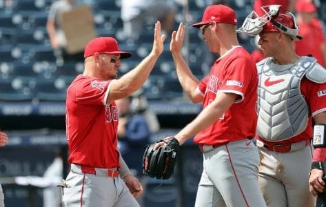 Los Angeles Angels designated hitter Mike Trout (27) and pitcher Ryan Johnson (32) high five after they beat the Tampa Bay Rays at George M. Steinbrenner Field.