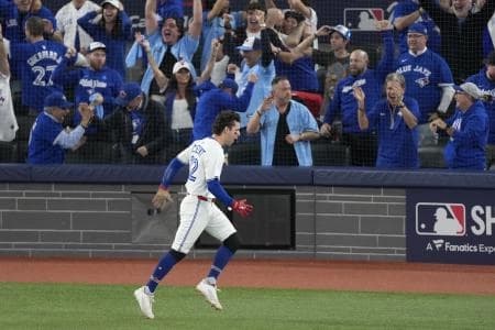 Toronto Blue Jays third baseman Ernie Clement (22) celebrates after scoring against the Los Angeles Dodgers in the sixth inning during game seven of the 2025 MLB World Series at Rogers Centre.