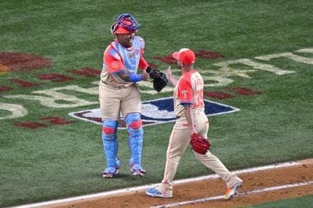 American League pitcher Kirby Yates of the Texas Rangers (39) and American League catcher Salvador Perez of the Kansas City Royals (13) come off the field after Yates pitches against the National League during the eighth inning of the 2024 MLB All-Star game at Globe Life Field.