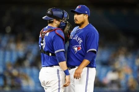 Toronto Blue Jays starting pitcher Hyun Jin Ryu (99) speaks to catcher Danny Jansen (9) during the sixth inning against the Baltimore Orioles at Rogers Centre.