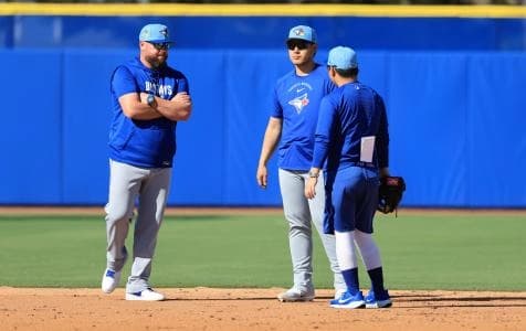 Toronto Blue Jays manager John Schneider (14) talks with infielder Kazuma Okamoto (7) during spring training practice at Player Development Complex