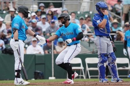 Miami Marlins shortstop Otto Lopez, center, is congratulated by Miami Marlins first baseman Liam Hicks (34) after hitting a home run in the first inning against the Toronto Blue Jays at Roger Dean Chevrolet Stadium.