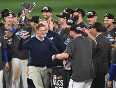 Toronto Blue Jays general manager Ross Atkins celebrates with manager John Schneider (14) after winning game seven of the ALCS round for the 2025 MLB playoffs against the Seattle Mariners at Rogers Centre.