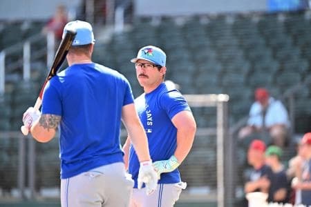 Toronto Blue Jays second baseman Davis Schneider (36) talks with catcher Tyler Heineman (55) before the start of the game against the Atlanta Braves during spring training at CoolToday Park.