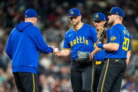 Seattle Mariners relief pitcher Austin Voth (30), second from left, is pulled by manager Dan Wilson, left, during a meeting at the mound with third baseman Josh Rojas (4), second from right, and first baseman Luke Raley (20) in the seventh inning against the Texas Rangers at T-Mobile Park.