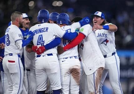 Toronto Blue Jays shortstop Andres Gimenez (0) celebrates with teammates after hitting a walk-off single against the Athletics at Rogers Centre.