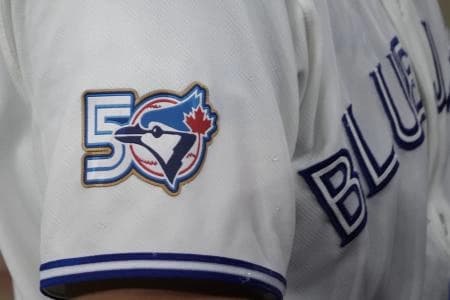 The Toronto Blue Jays 50th anniversary logo displayed on the jersey of third baseman Kazuma Okamoto (7) duringa game against the Athletics at Rogers Centre