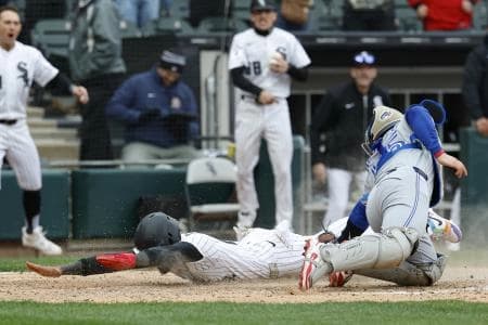 Chicago White Sox center fielder Derek Hill (25) scores as Toronto Blue Jays catcher Tyler Heineman (55) is unable to tag him out at home plate during the 10th inning at Rate Field.