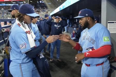 Toronto Blue Jays starting pitcher Kevin Gausman (34) and first baseman Vladimir Guerrero Jr. (27) shake hans before the start of the game against the Colorado Rockies at Rogers Centre.
