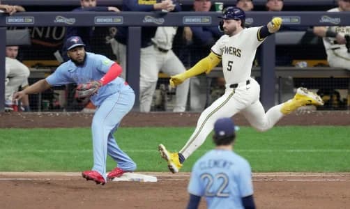 Milwaukee Brewers center fielder Garrett Mitchell (5) beats the throws to Toronto Blue Jays first baseman Vladimir Guerrero Jr. (27) during the eighth inning of their game Tuesday, April 14, 2026 at American Family Field in Milwaukee, Wisconsin.