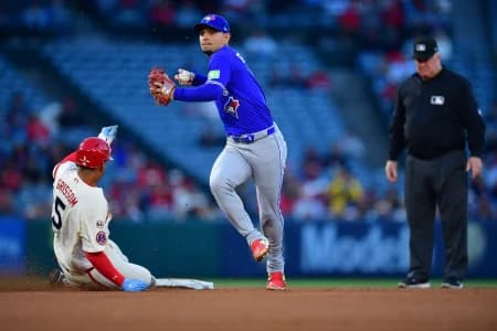 Los Angeles Angels second baseman Vaughn Grissom (5) is out at second as Toronto Blue Jays shortstop Andres Gimenez (0) throws to first for the out against catcher Logan O'Hoppe (14) during the third inning at Angel Stadium.