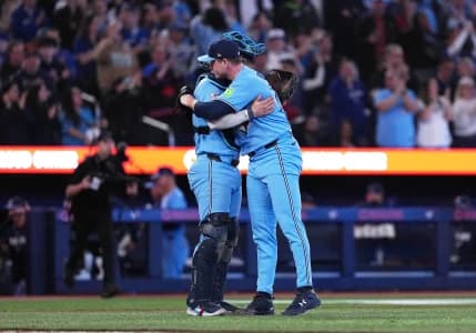 Toronto Blue Jays catcher Tyler Heineman (55) celebrates the win with relief pitcher Louis Varland (77) against the Boston Red Sox at the end of the ninth inning at Rogers Centre.