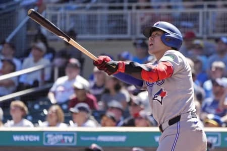 Toronto Blue Jays third baseman Kazuma Okamoto (7) hits a two run home run against the Minnesota Twins in the ninth inning at Target Field.