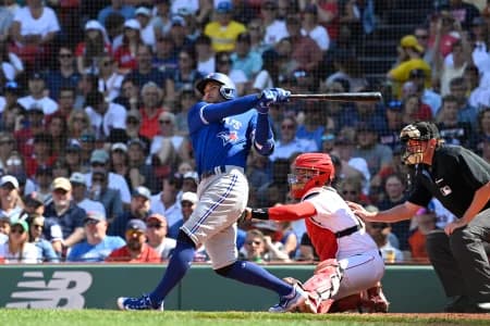Toronto Blue Jays designated hitter George Springer (4) hits a sacrifice fly allowing shortstop Paul DeJong (10) to score against the Boston Red Sox during the fifth inning at Fenway Park.