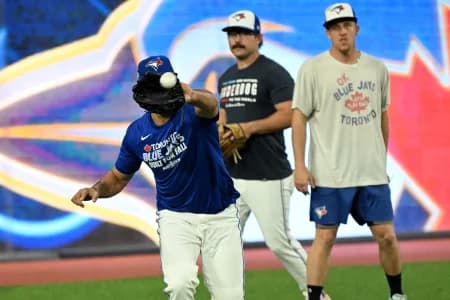 Toronto Blue Jays outfielders Myles Straw (3) and Davis Schneider (36) watch outfielder Anthony Santander (25) make a catch during workouts for the American League Championship Series at Rogers Centre.