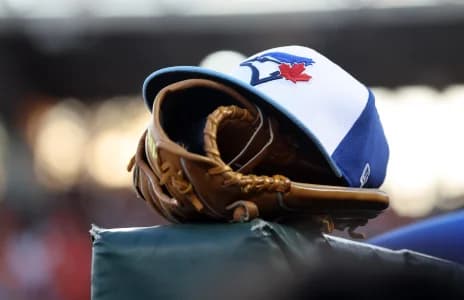 A detail view of a Toronto Blue Jays hat and glove against the Baltimore Orioles at Ed Smith Stadium.