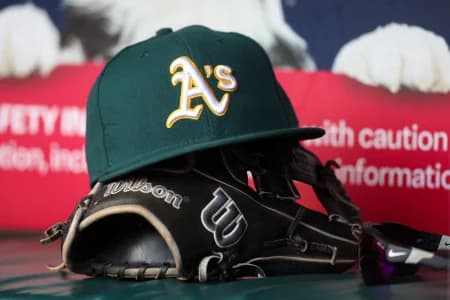 A detailed view of an Oakland Athletics hat and glove on the field against the Atlanta Braves in the sixth inning at Truist Park