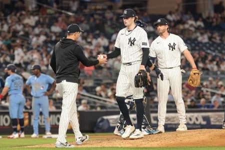New York Yankees manager Aaron Boone (17) take the ball from pitcher Cam Schlittler (31) during the seventh inning against the Toronto Blue Jays at Yankee Stadium.